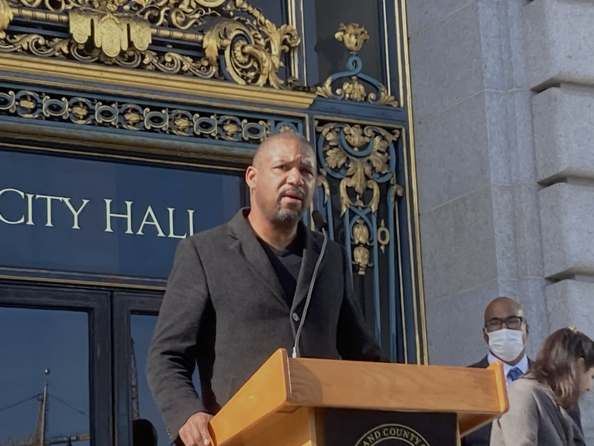 A man speaks at a podium at City Hall
