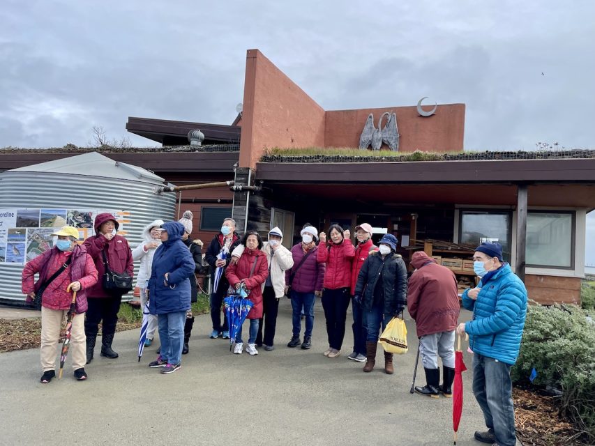 Some seniors taking a group photo in front of a building