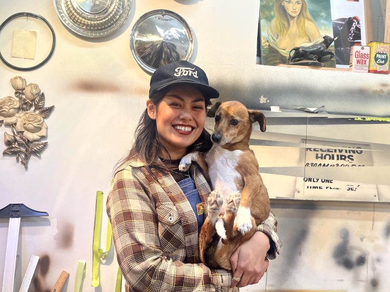 Woman holding dog in art studio