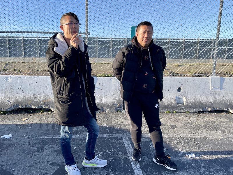 Two people standing and smoking