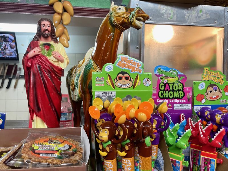 A scene with candy, a statue of Jesus, knives in the background.