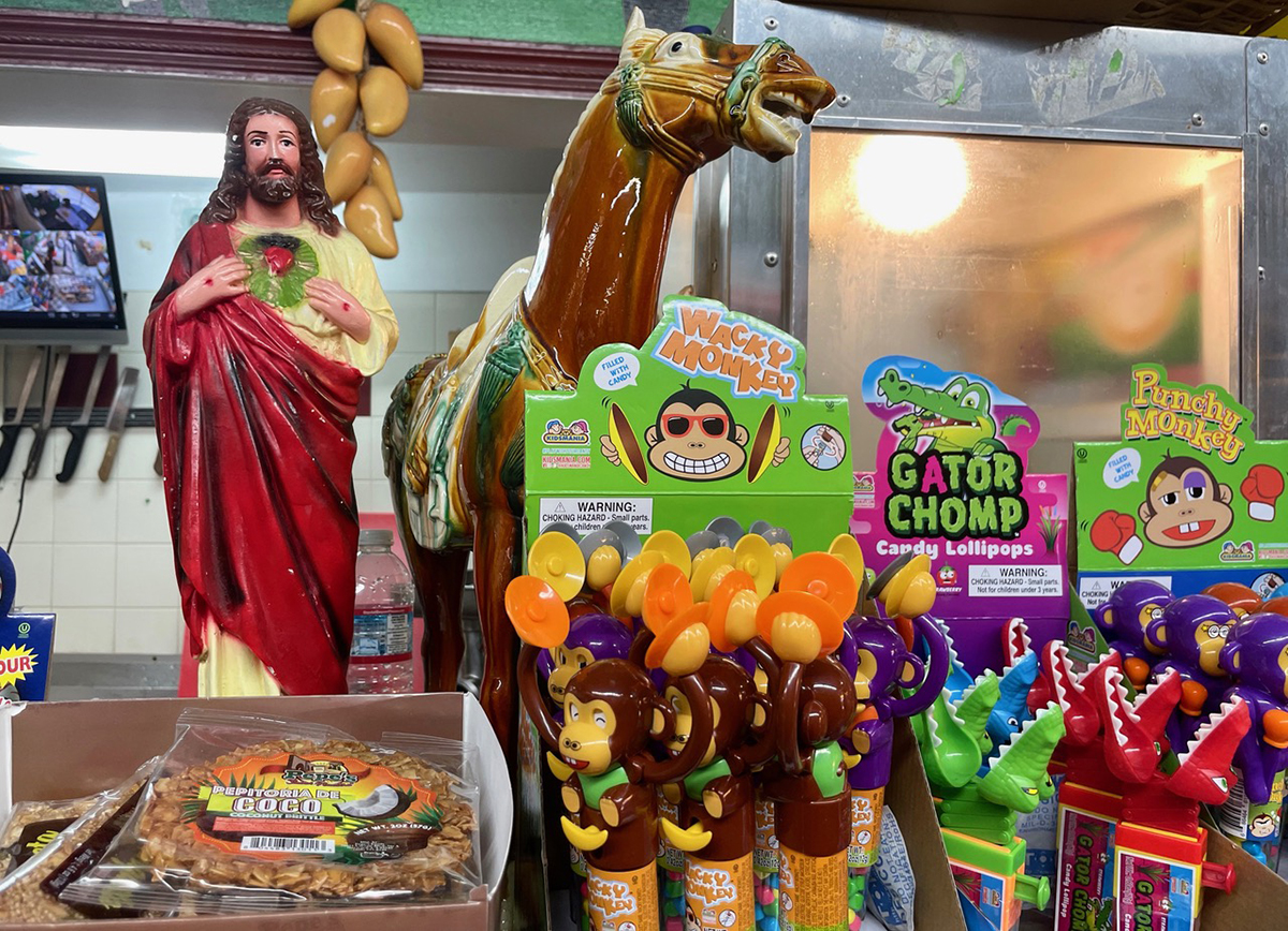 A scene with candy, a statue of Jesus, knives in the background.
