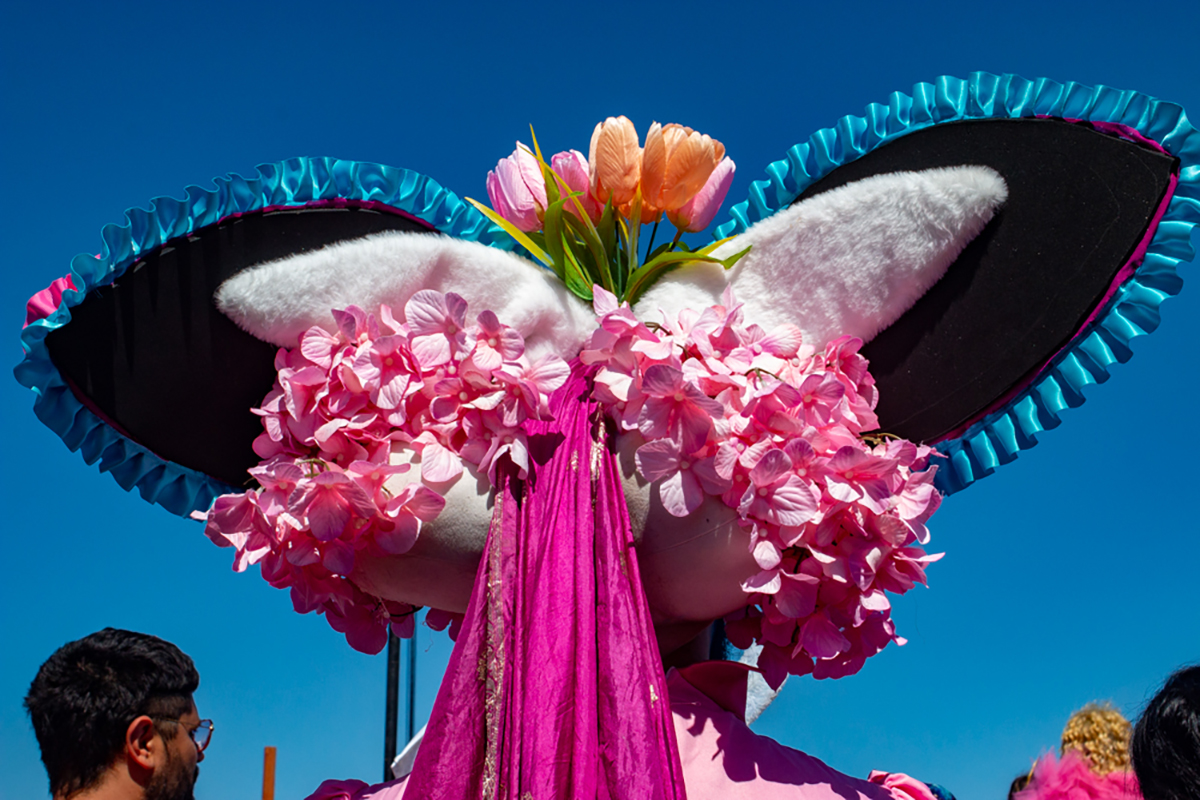 The back of a headdress filled with pink flowers and ribbons.