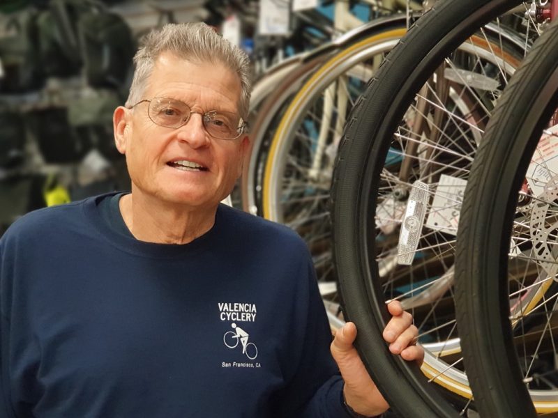 Paul Olszewski, the owner of the Valencia Cyclery, stands next to several bikes on display at his shop.