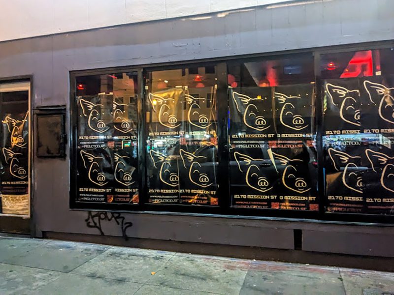 A wall of posters with a pig's head.