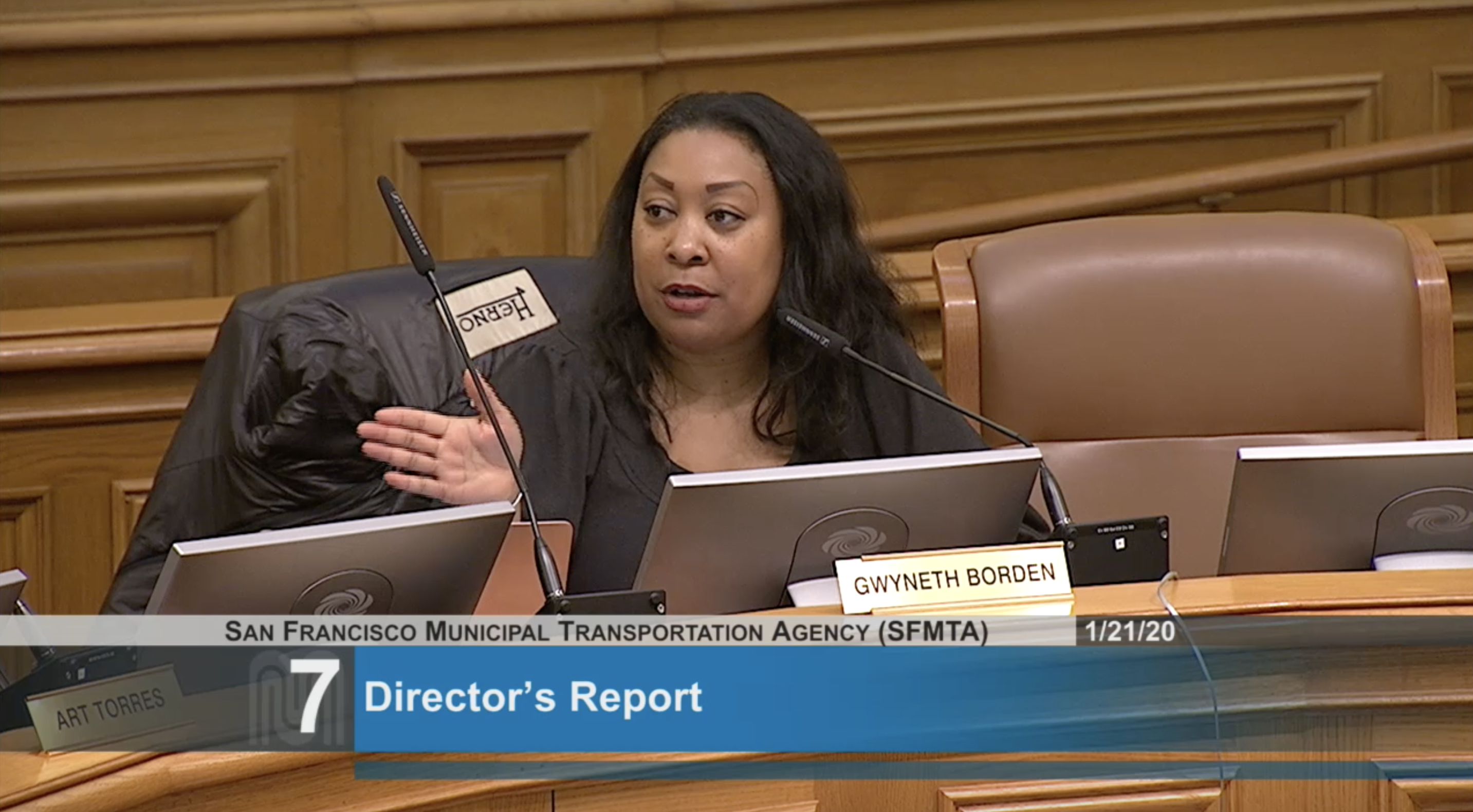 Gwyneth Borden sitting in a chair at an MTA board meeting