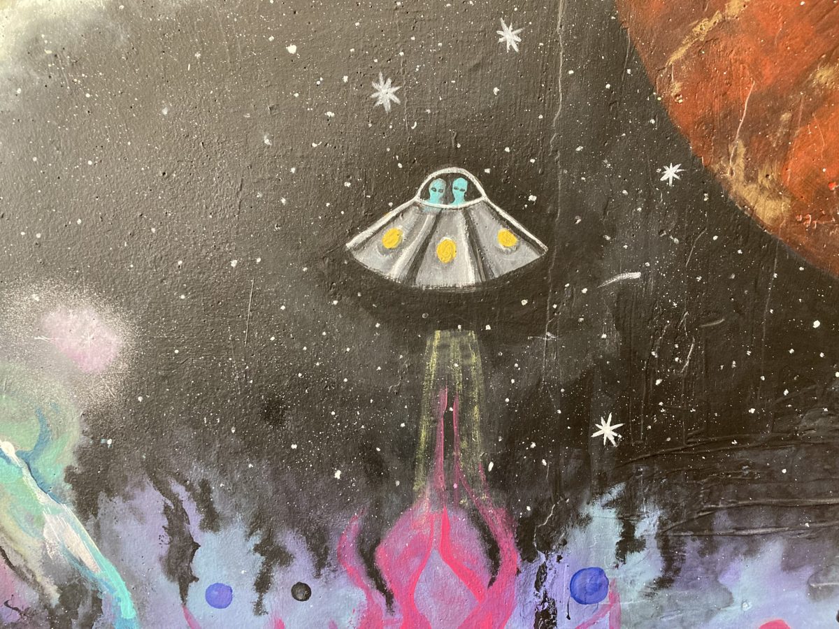 a UFO against a dark sky with an orange planet to the right