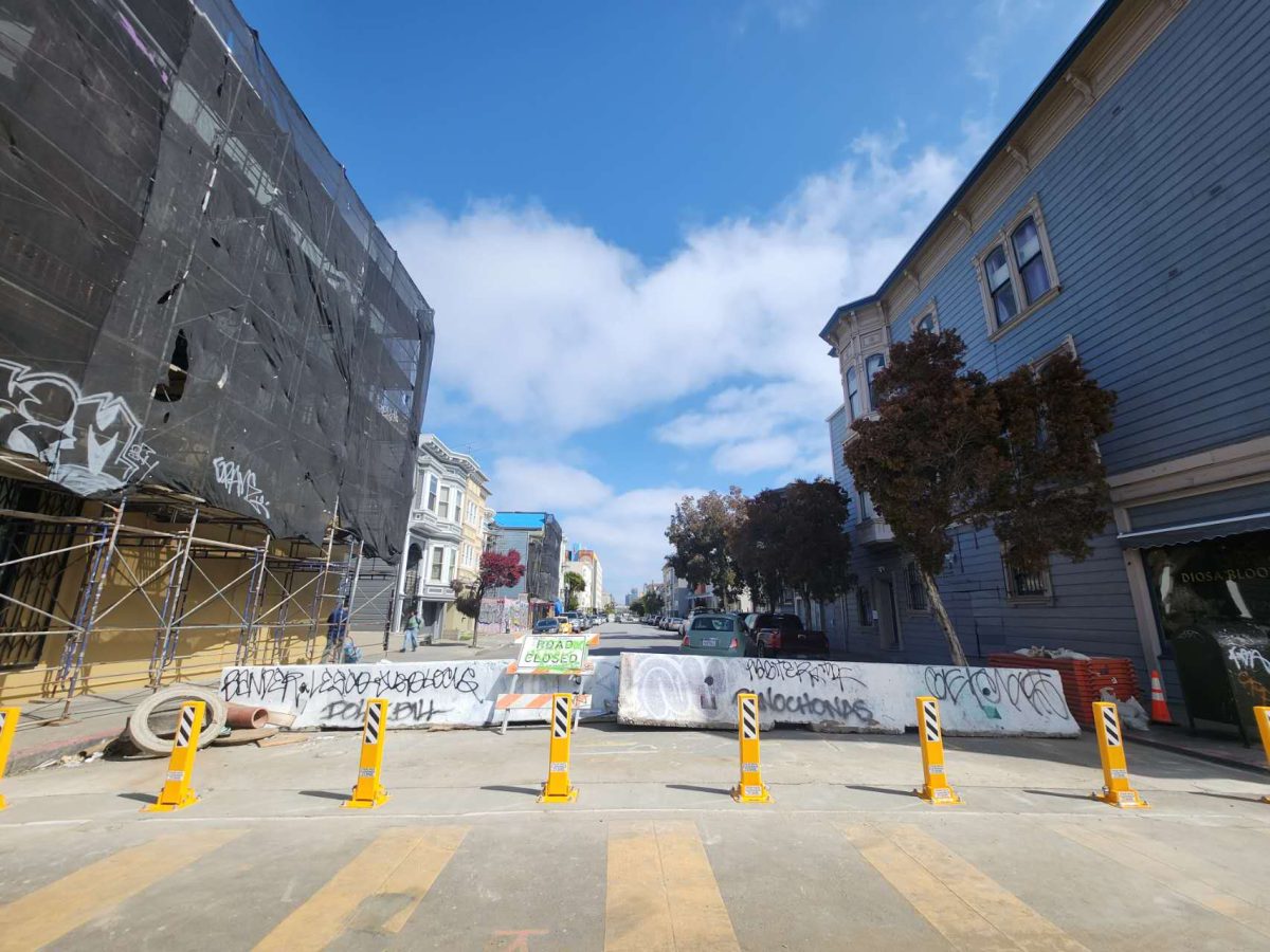 steel bollards blocking off a street, between buildings