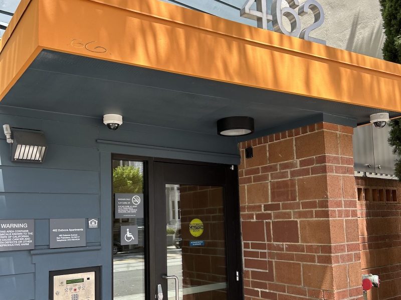 A big '462' is showing off the address of a blue and orange senior affordable housing complex.