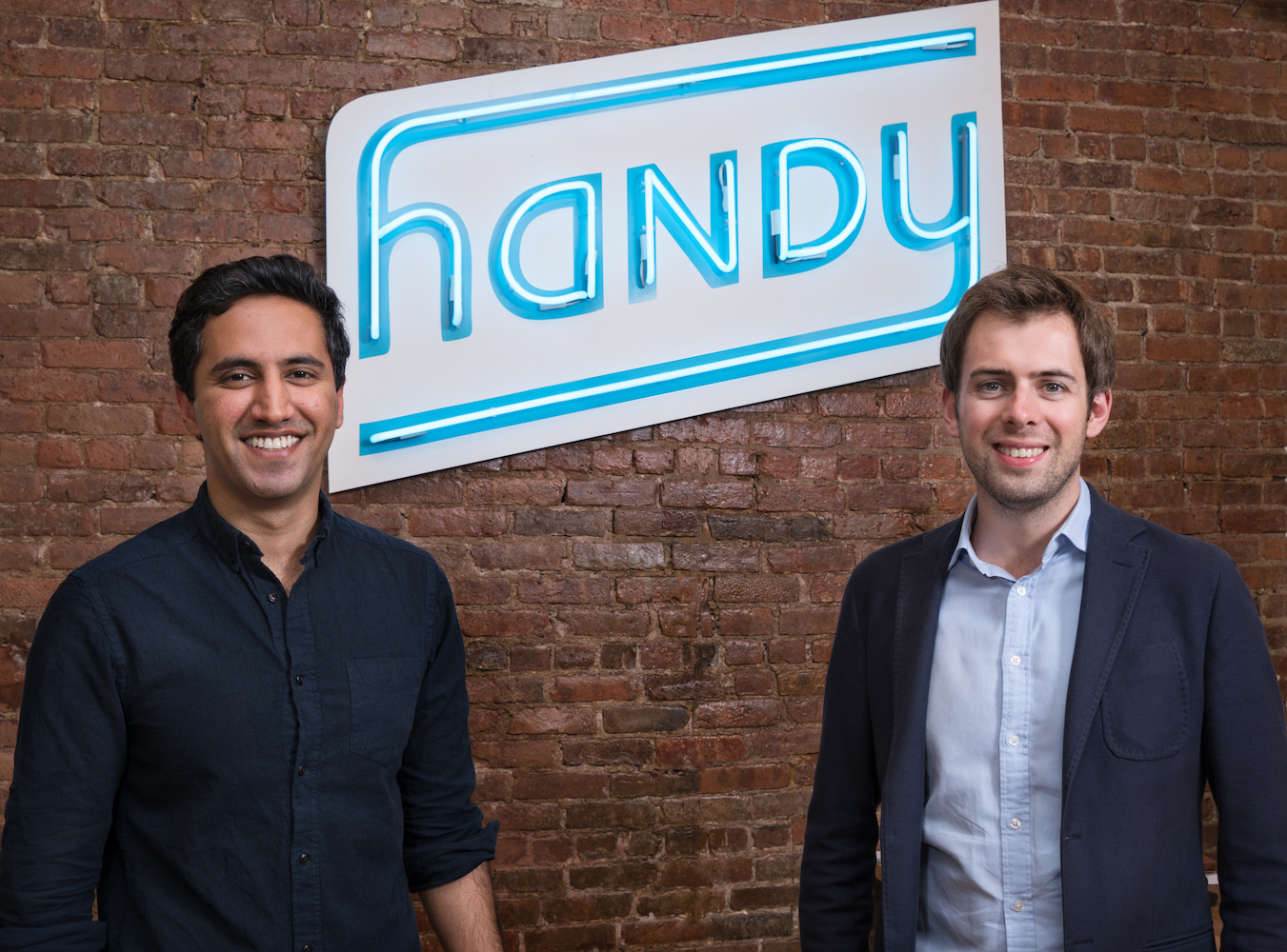 Two people standing in front of a wall