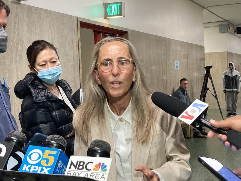 a woman speaks into microphones