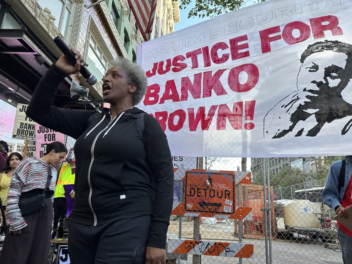 woman with mic in front of banner reading "justice for banko brown"