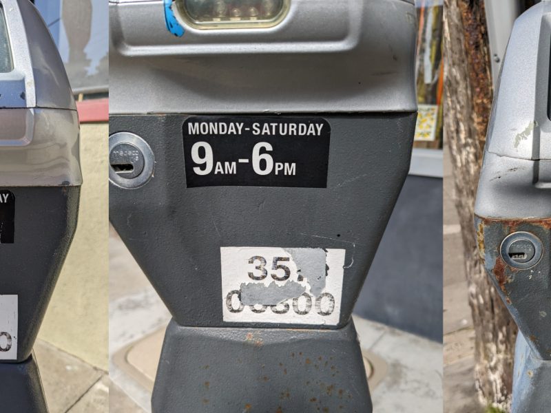 Three parking meters with their numbers scratched off.