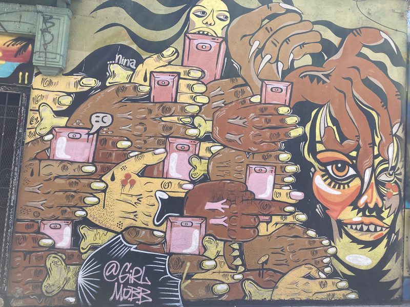A face painted on a wall with brown and pink colors.