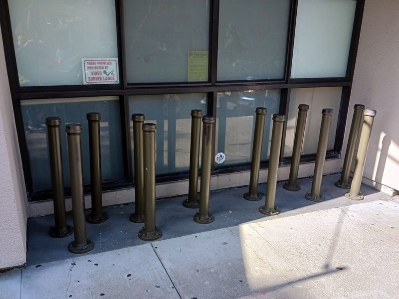The ledge of a ground floor window with pipes blocking the pavement.