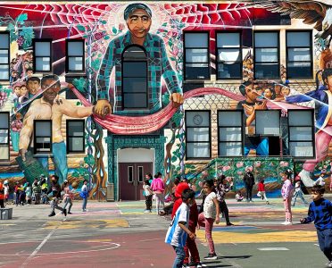 A big mural overlooking a playground where children are playing.