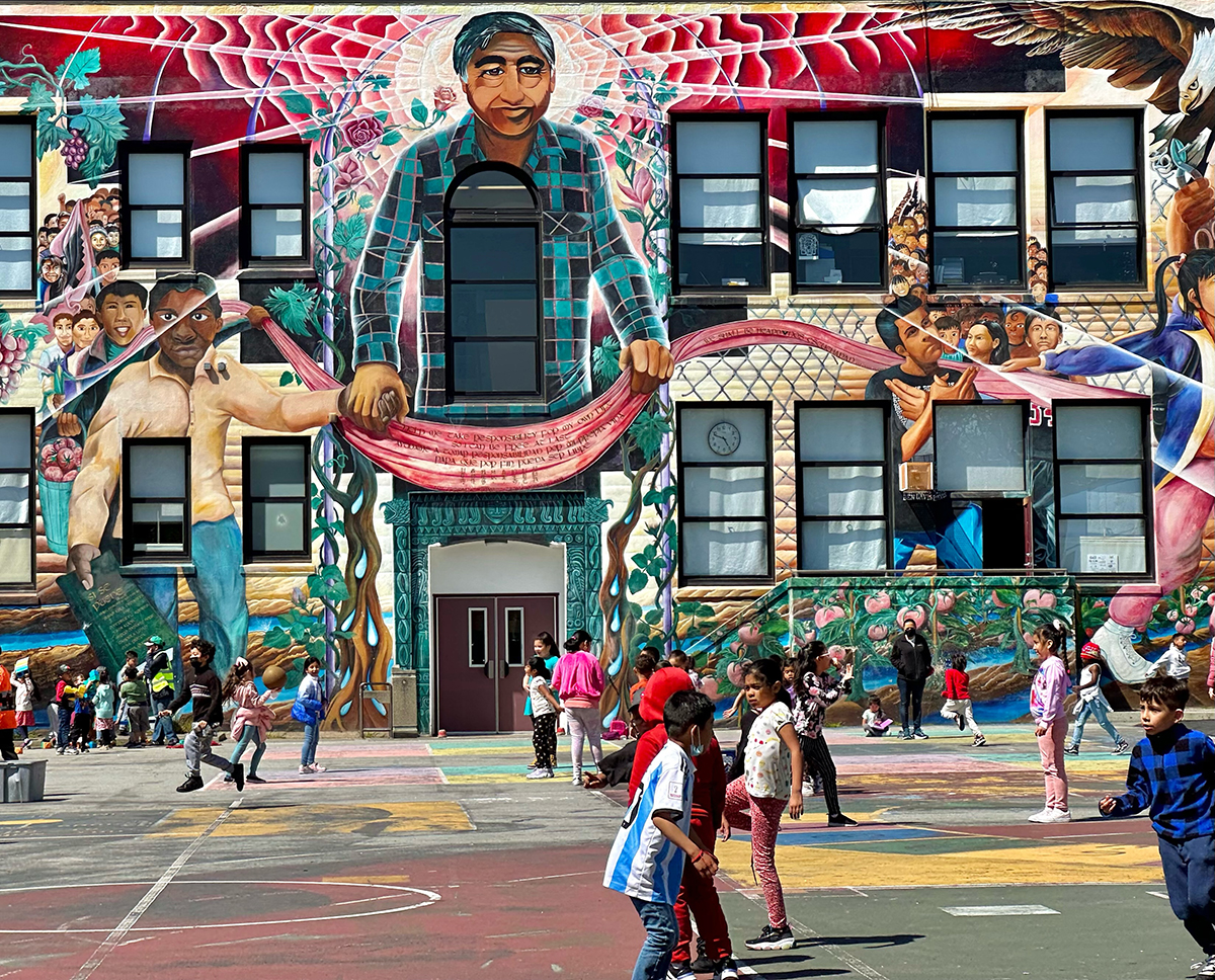 A big mural overlooking a playground where children are playing.