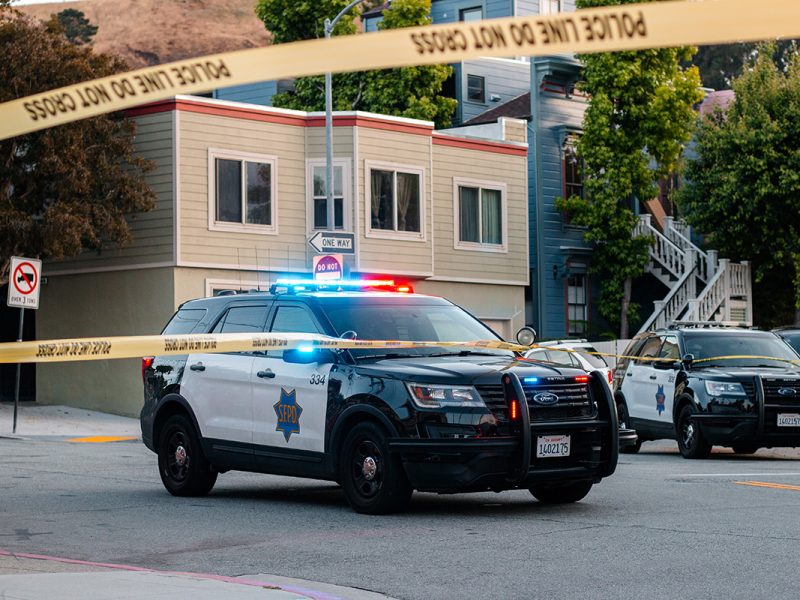 A police car and police line yellow tape.