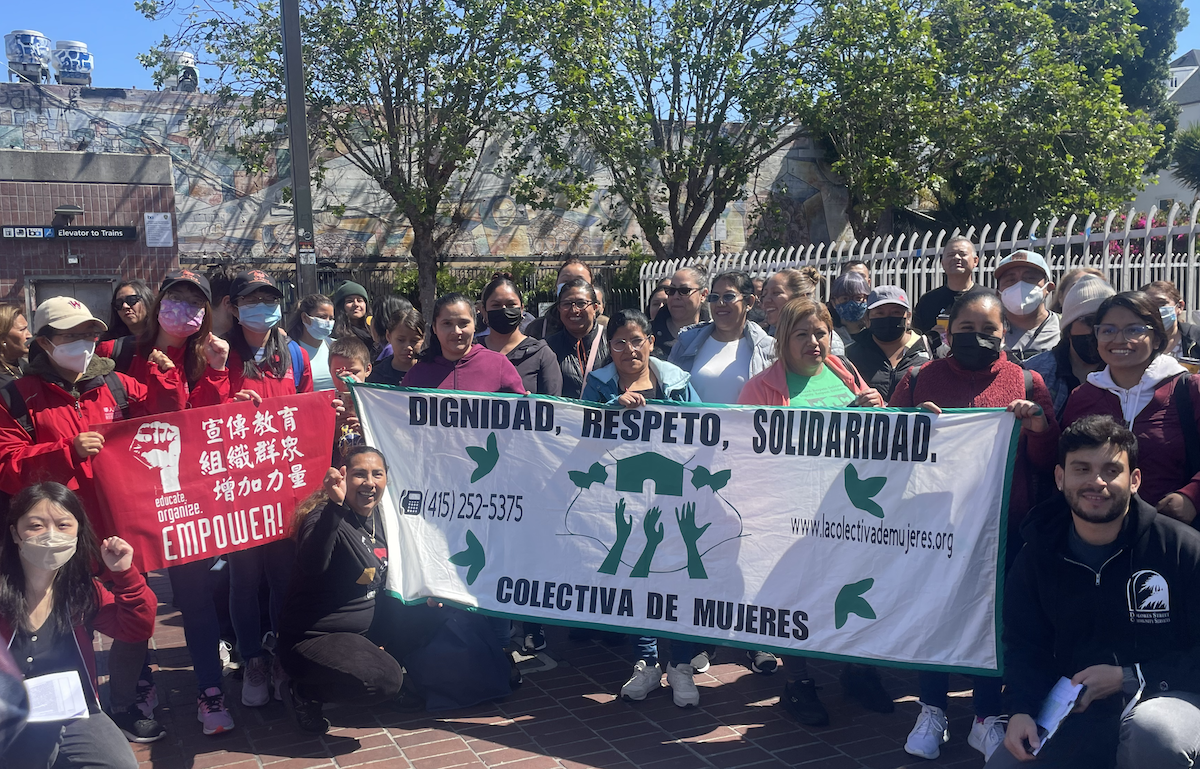 Thirty to forty people gather holding signs saying Chinese Progressive Association and La Colectiva de Mujeres.