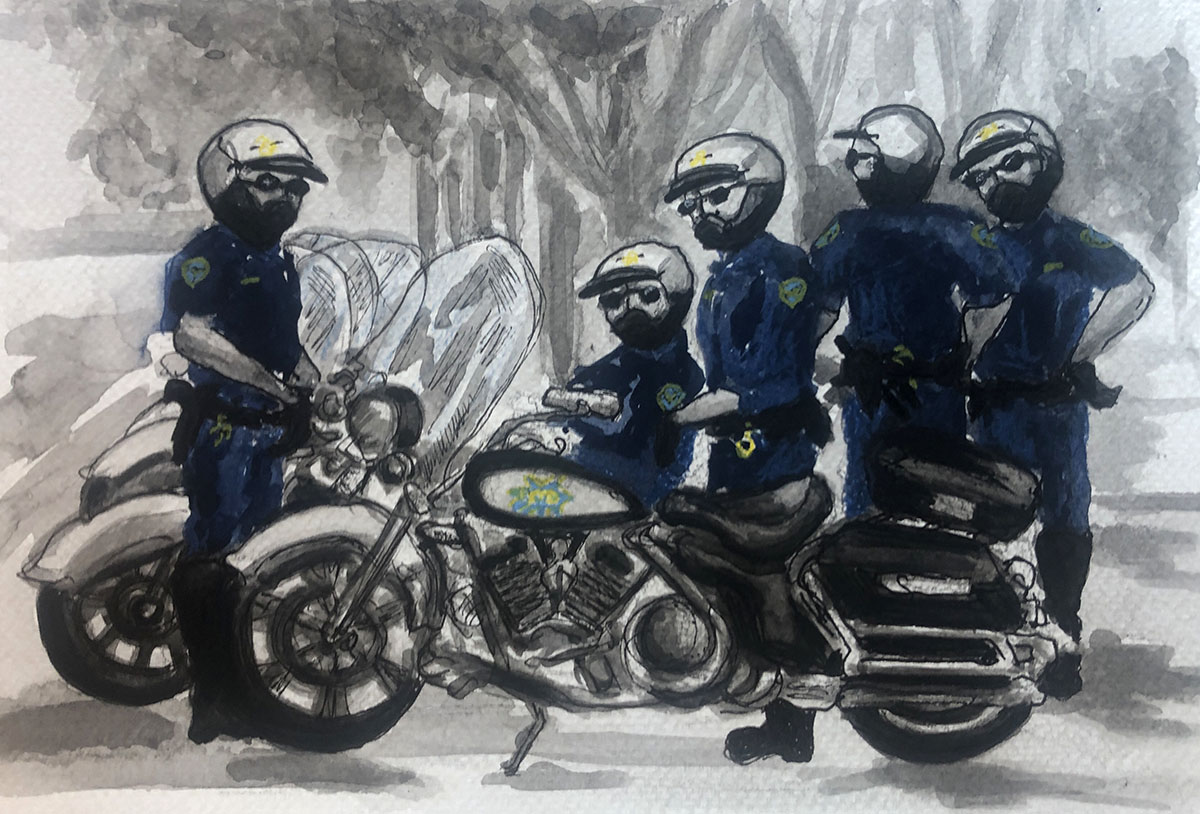 Two officers on motorbikes and three others standing around.