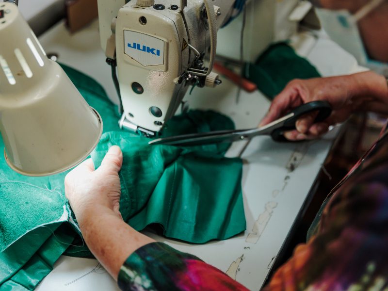 A person sewing and repairing a garment for the Goodwill project.