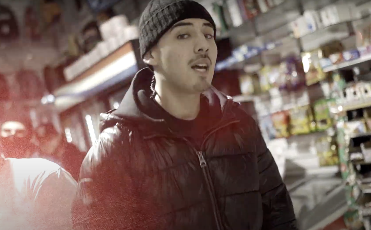 Javier Campos, with a beanie, rapping.