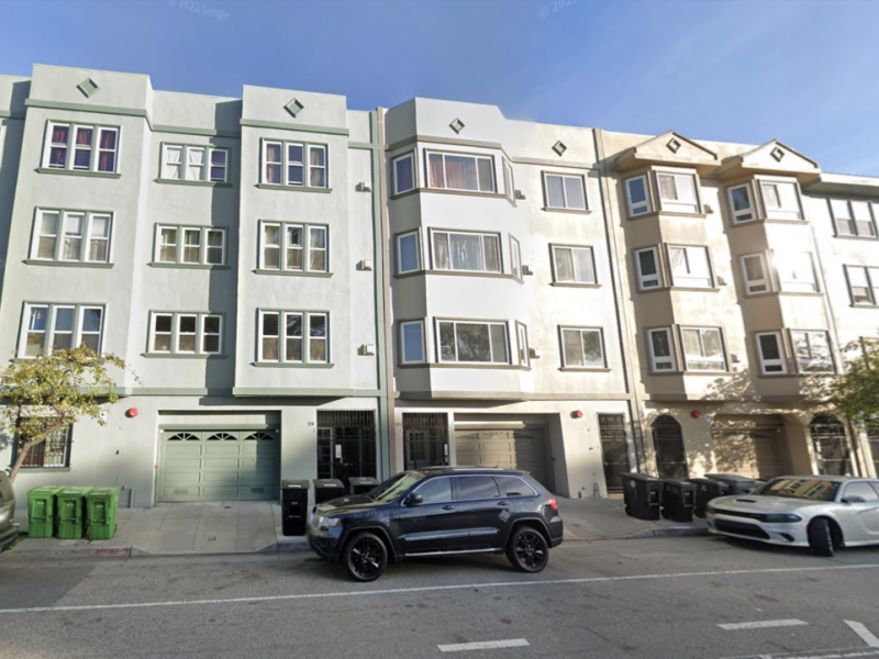 Four rectangular residential buildings on a street.