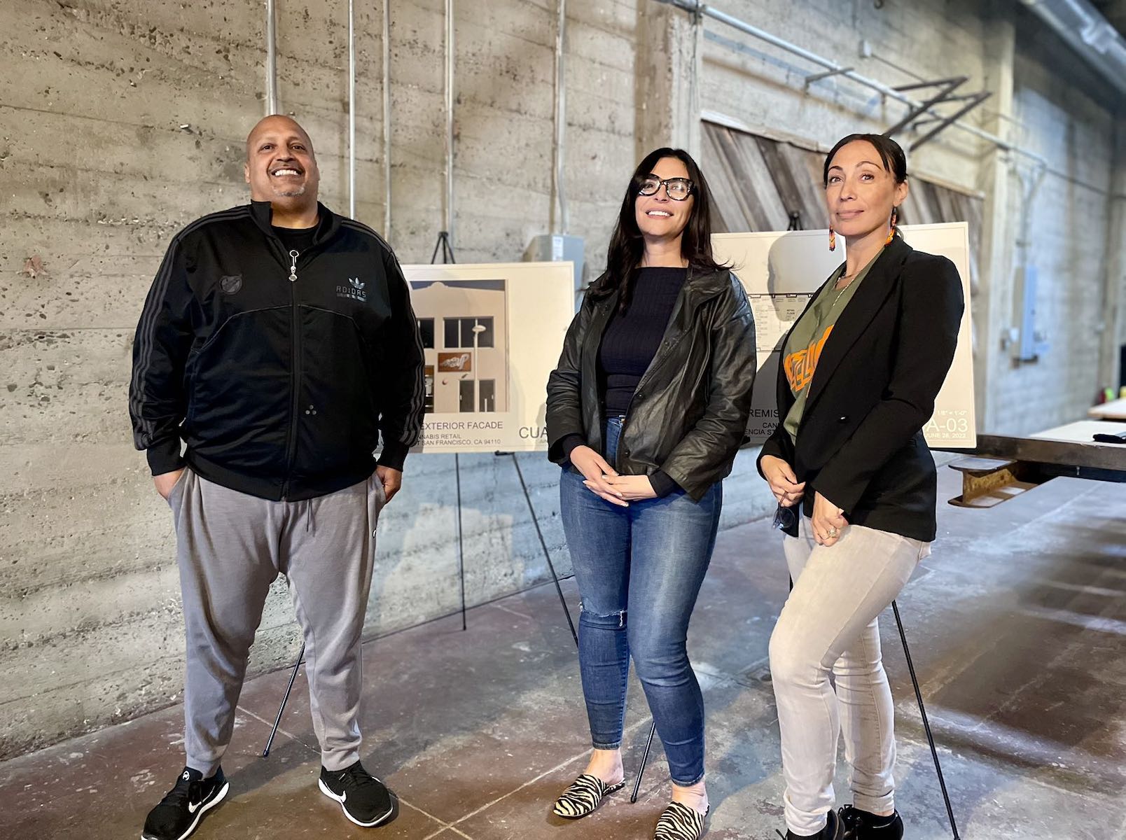 Three people standing in a large room.