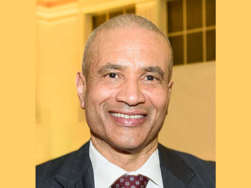 Harlan Kelly in front of a yellow background.