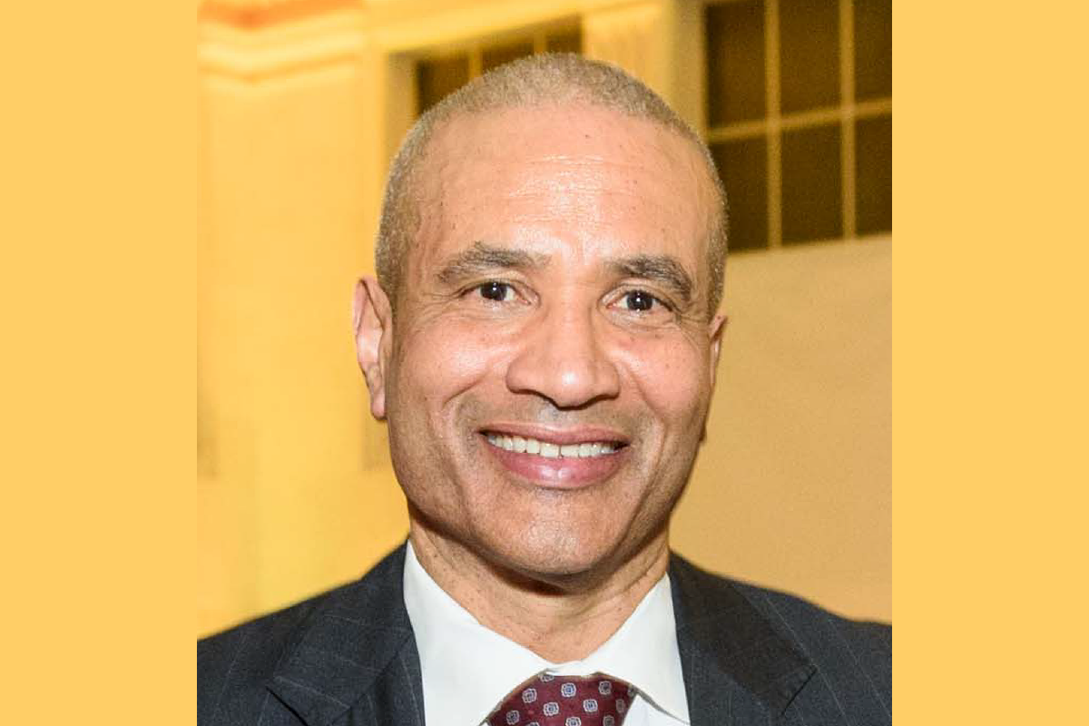 Harlan Kelly in front of a yellow background.