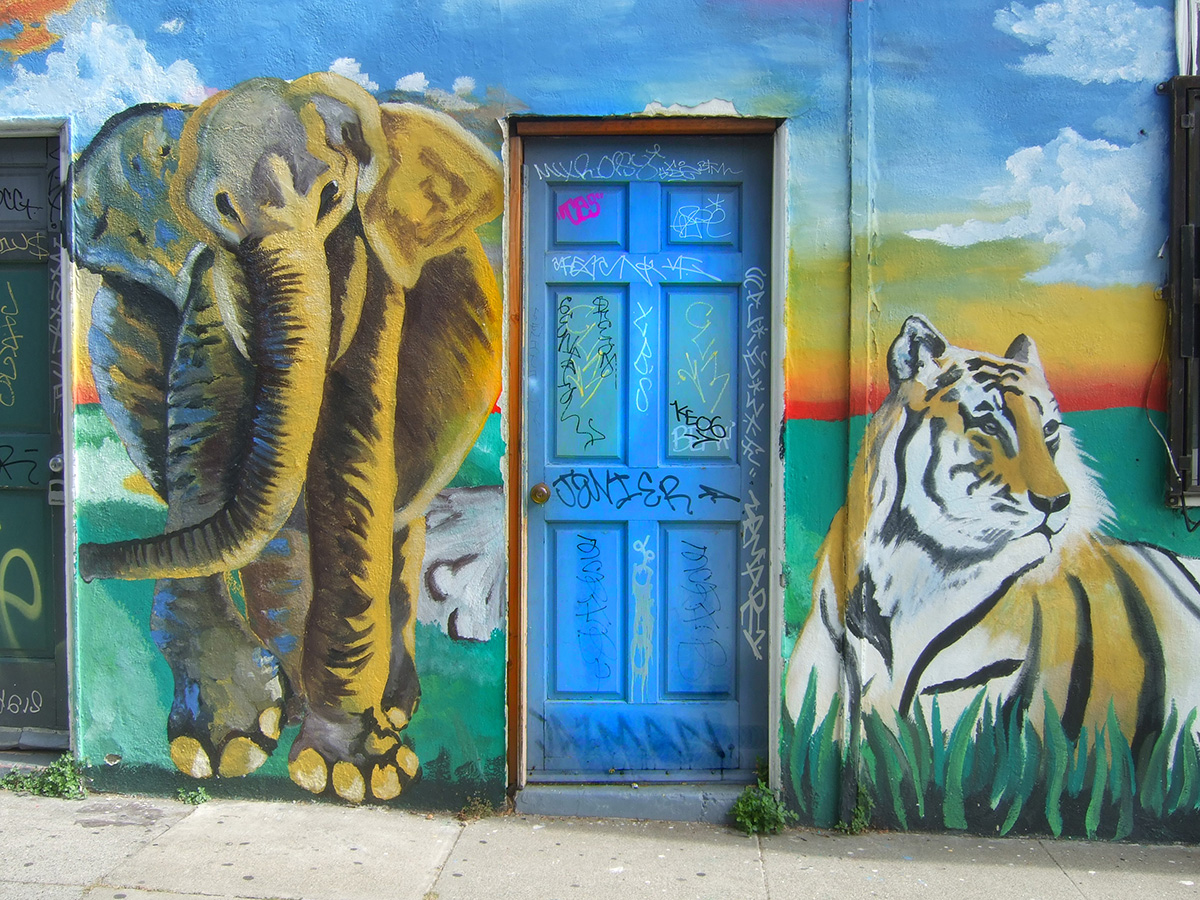 A wall with a painting of an elephant and tiger