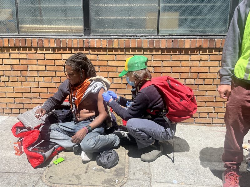 man vaccine nurse hat brick sidewalk