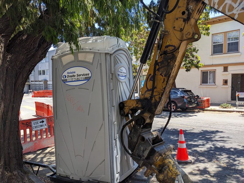 A port apotty with the big arm of an industrial arm in front of it.