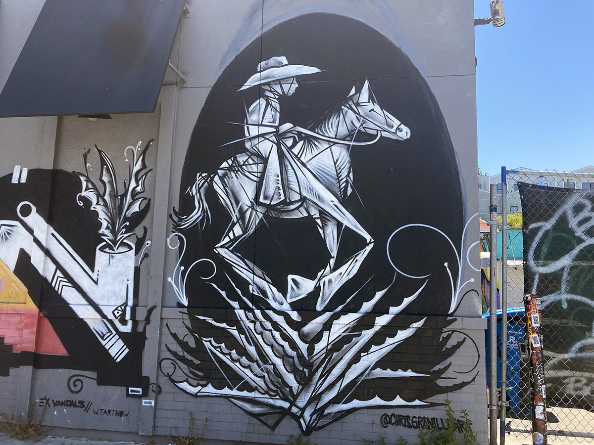 A man on a donkey in a black and white mural.