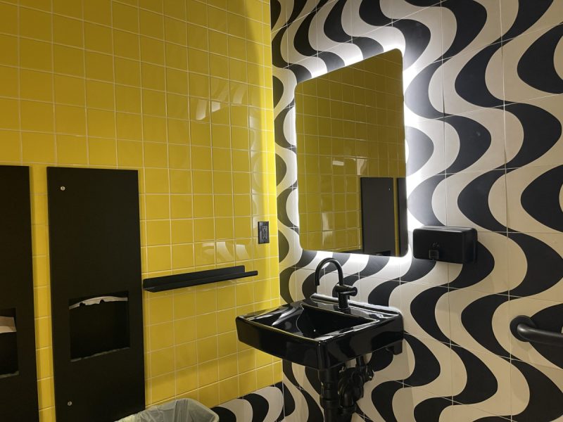 El Rio's ADA restroom glows in yellow hues with black undulating textiles.