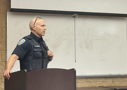 A man in an SFPD uniform stands at a podium.