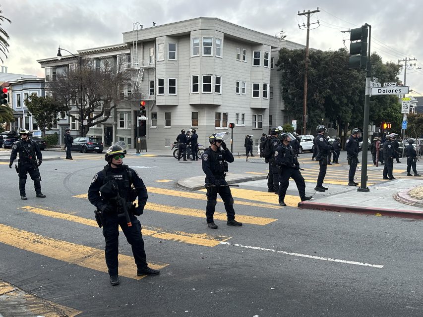 San Francisco police officers lined up at the intersection of 19th and Dolores streets during the shutdown of the hill bomb.