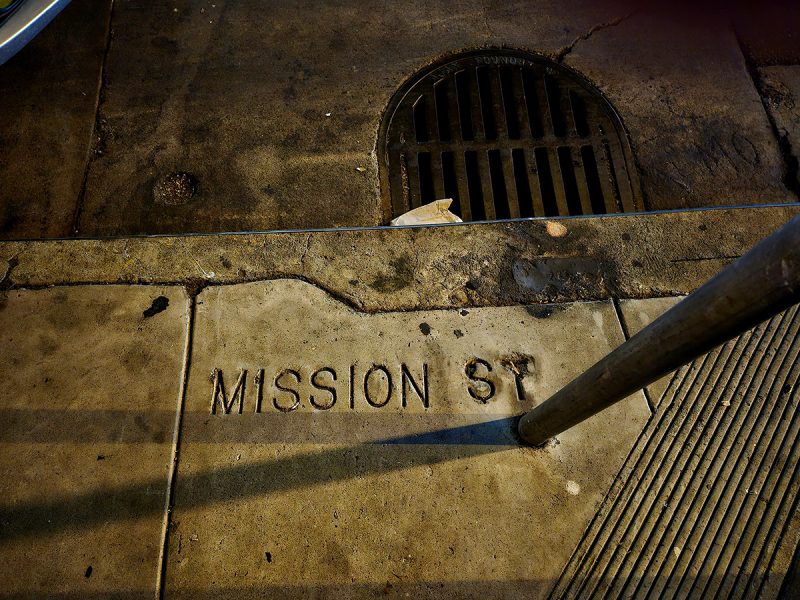 A sidewalk with the words Mission Street.