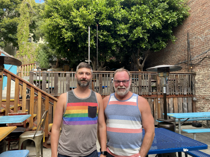 New owners of Teeth, Brooke Lloyd (left) and Robert Sill (right), standing in the patio of the bar.