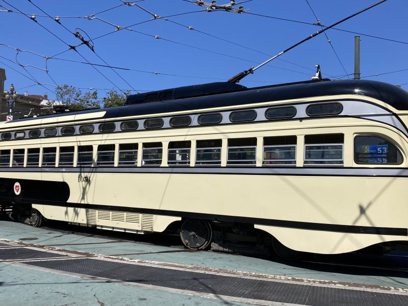 A beige color train with the number 1056 on it on Market Street.