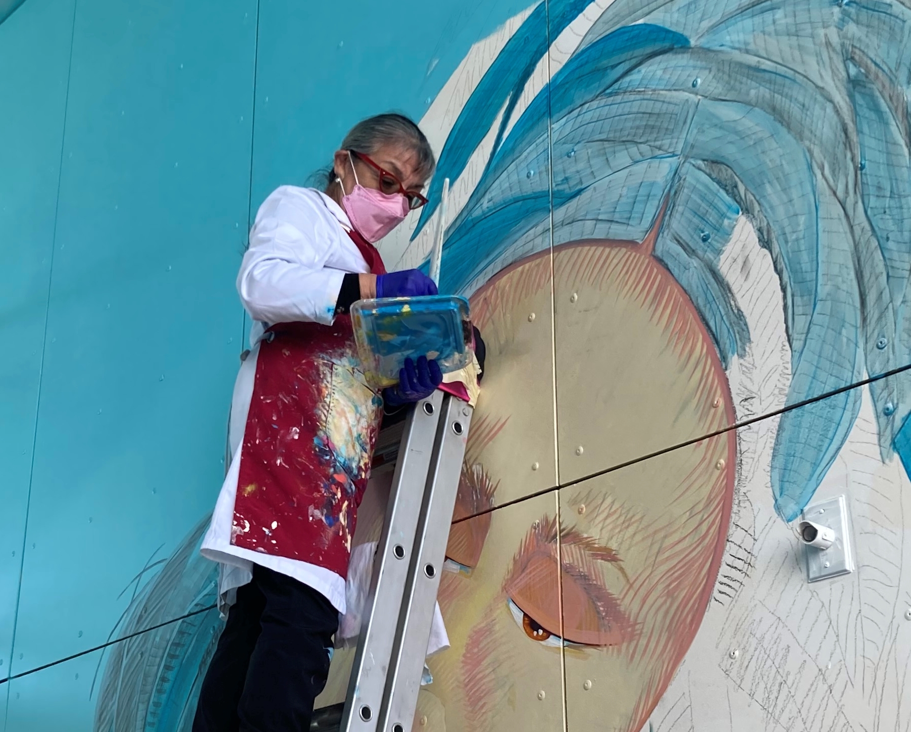 A muralist painting a wall.