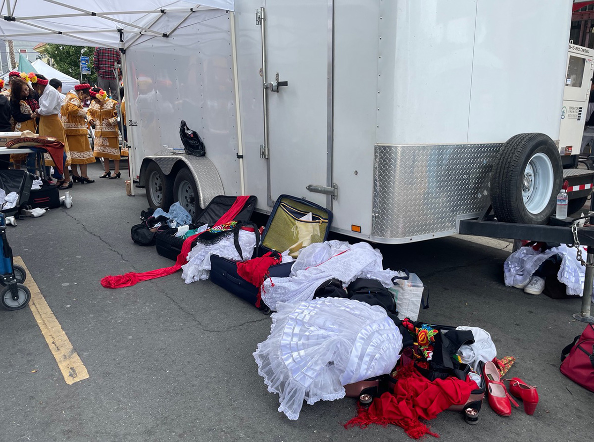 Dancers in the background with piles of clothing in the foreground.