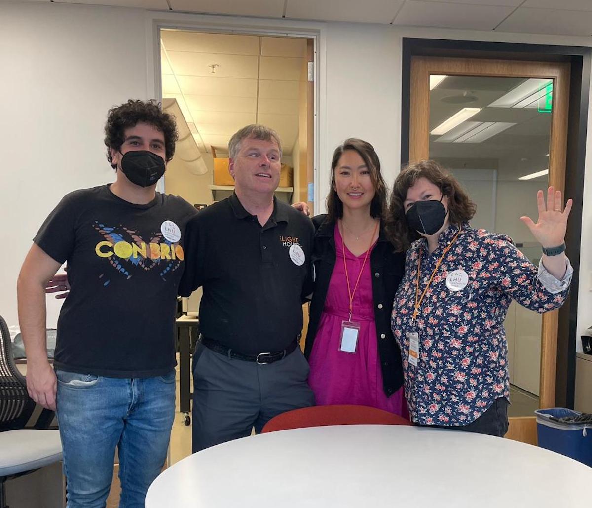 Four people hugging each other.