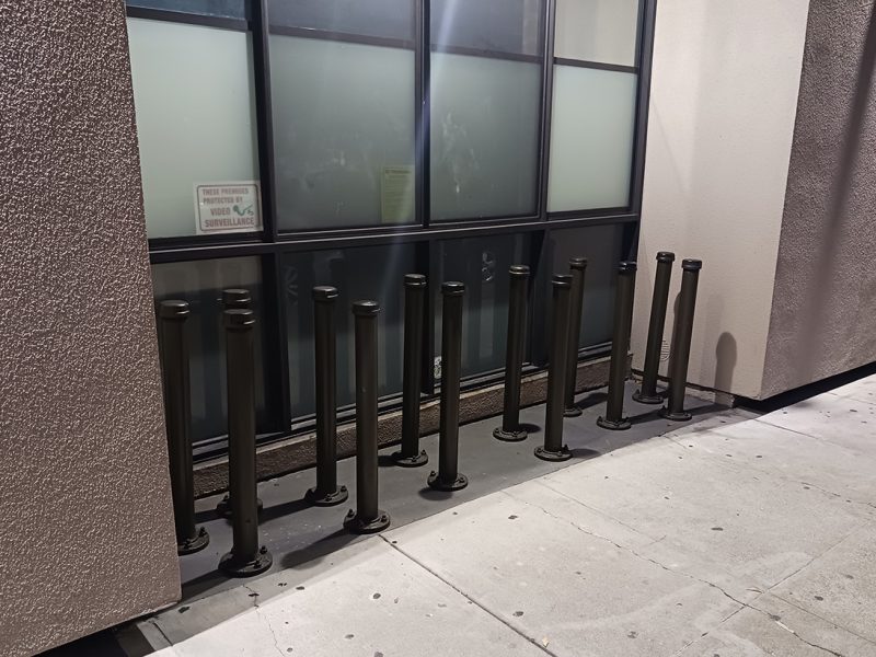 Poles coming up from an inset in the sidewalk.