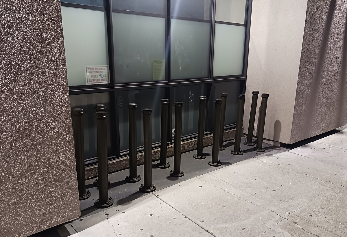 Poles coming up from an inset in the sidewalk.