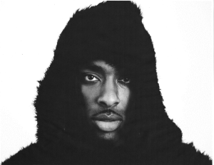 A black and white photo of a man in a furry hoodie.
