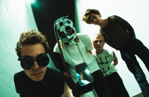 A group of people standing in a hallway with masks on.
