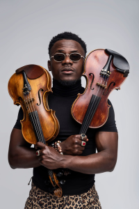 A man with sunglasses holding two violins.