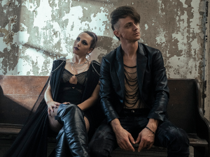 Two people sitting on a bench in an abandoned building.