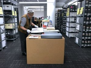 A man standing in a room full of boxes.